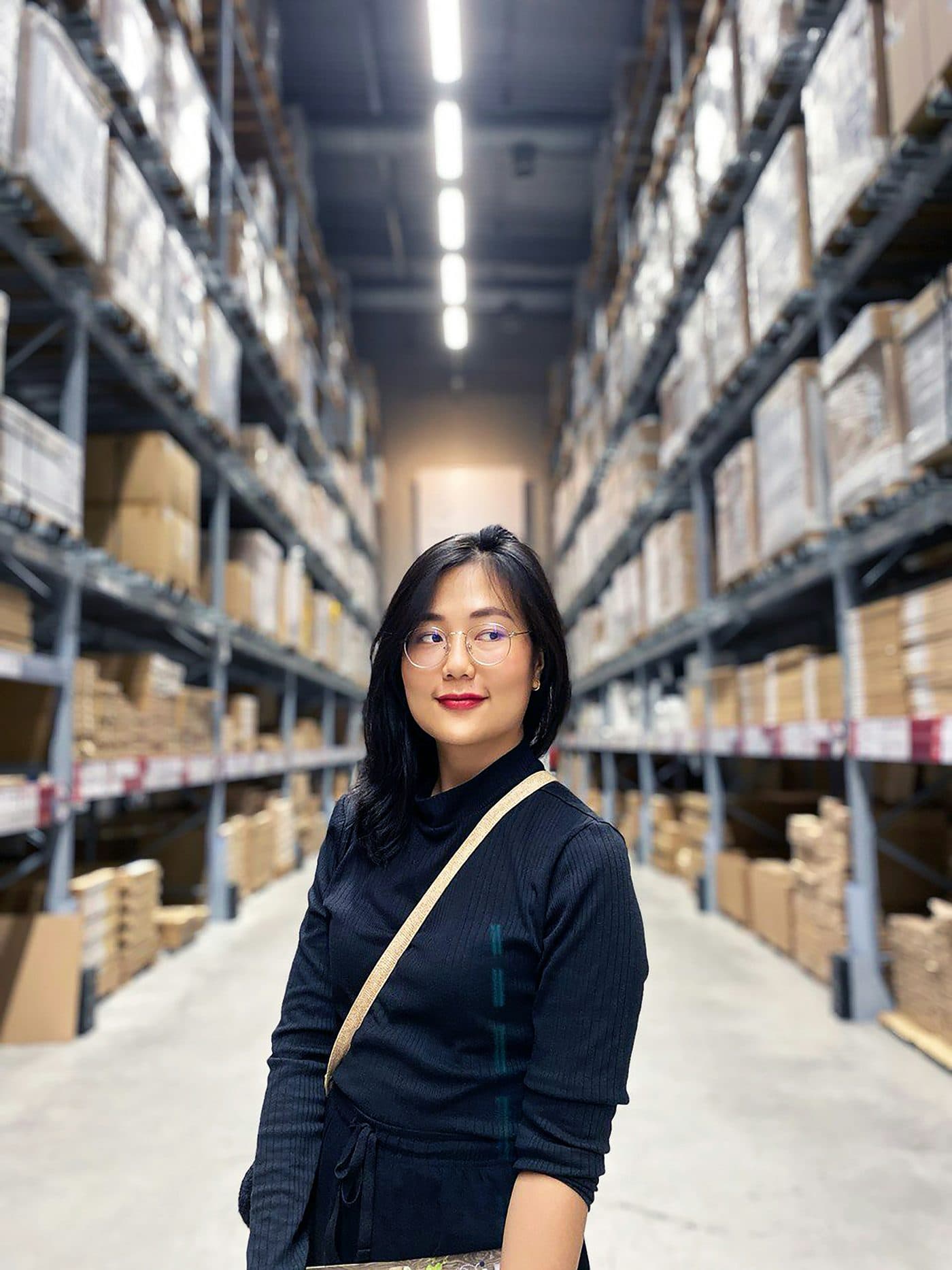 Logistics centre employee among warehouse shelves