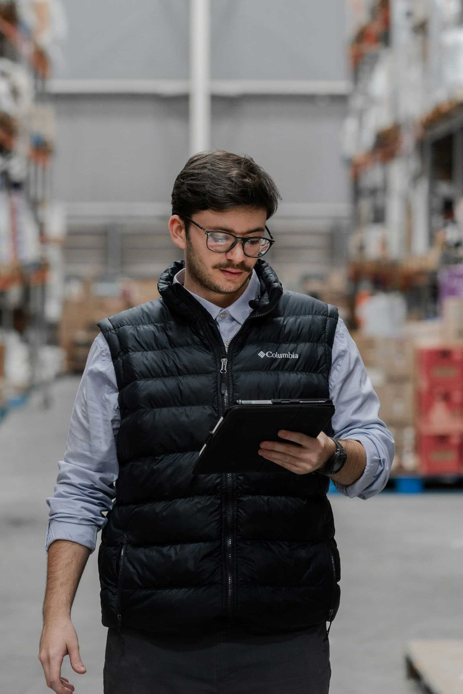 Manager checking warehouse stock with a tablet